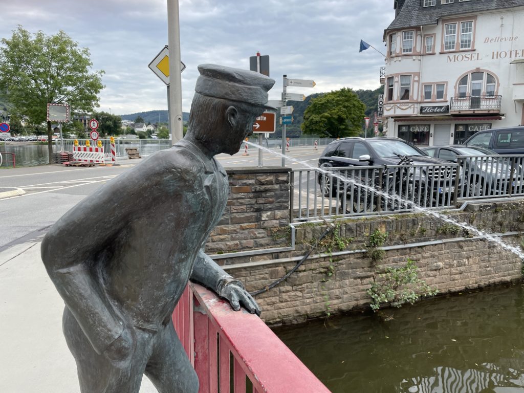 Skulptur eines Wasser spuckenden Mannes